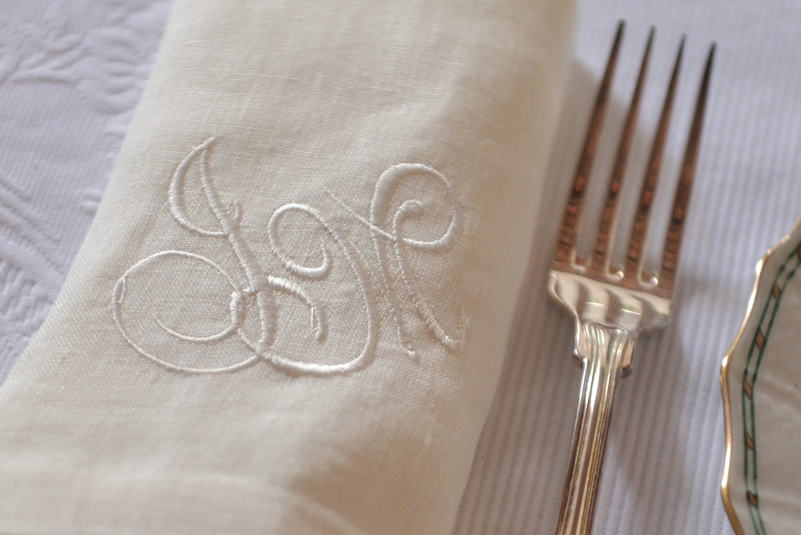 A napkin that has an embroidered monogram.